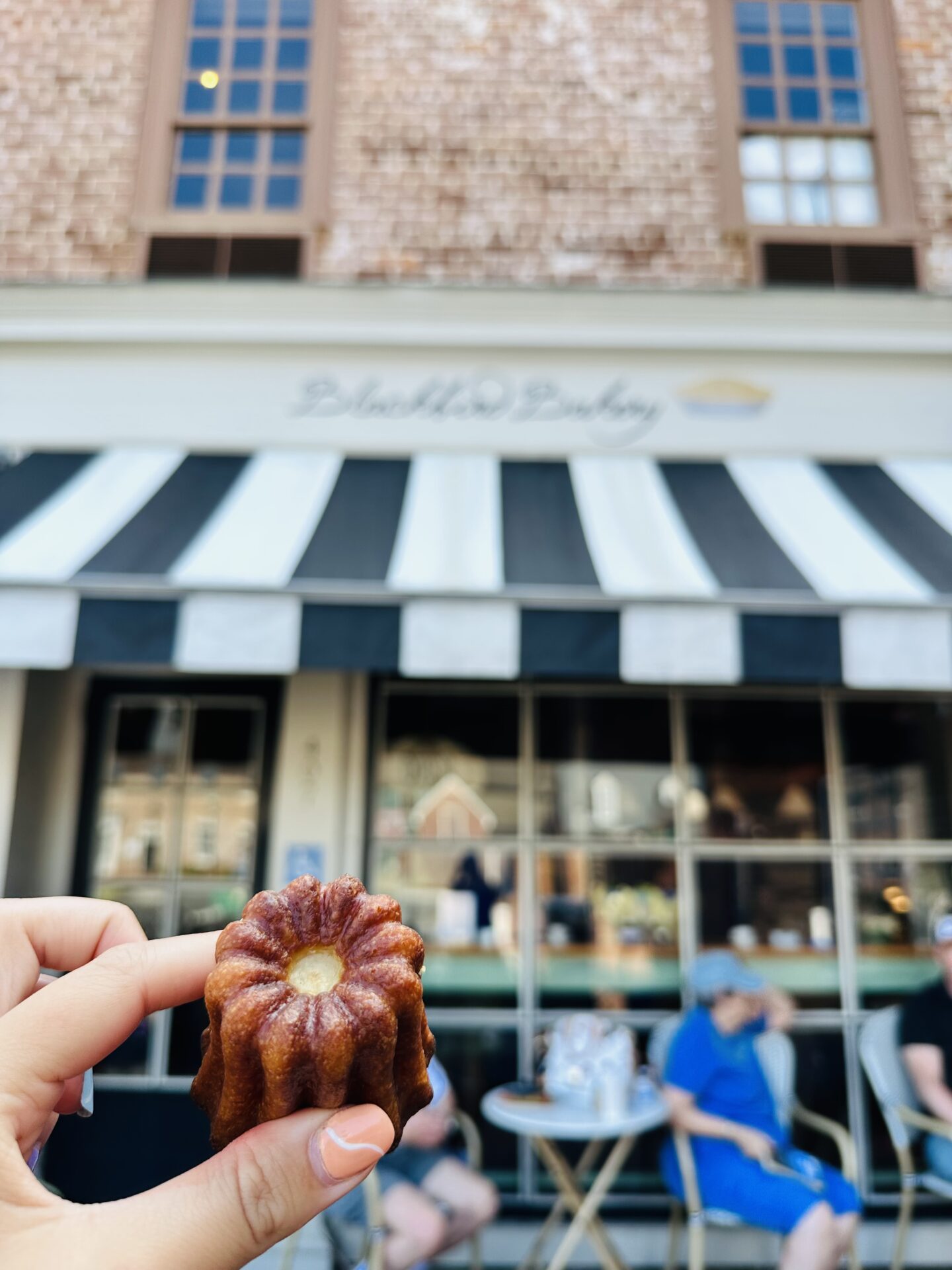 Eastern virginia: a person holding a cannele outside of Blackbird Bakery in Yorktown