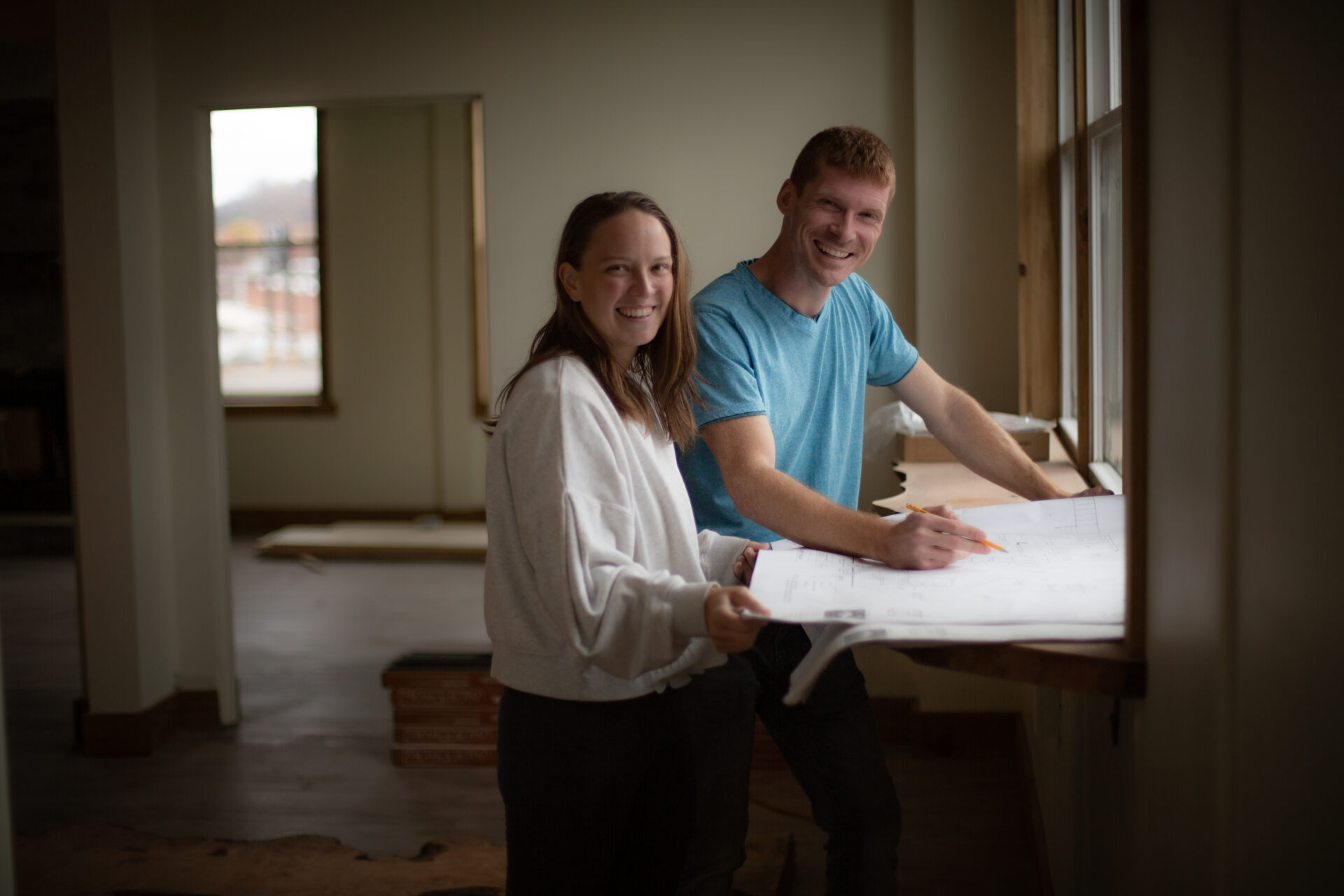 Jessica and Jesse Shelton share traditional tea service and a liberal arts philosophy in Johnson City, Tennessee at the philosophers house. They are pictured around a counter holding a pencil and business model plans