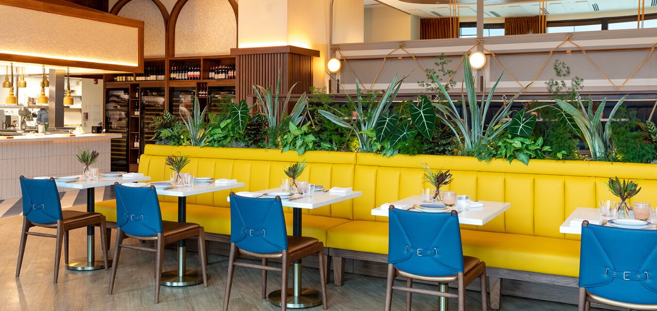Costa interior with yellow booths, blue chairs, and funky lighting