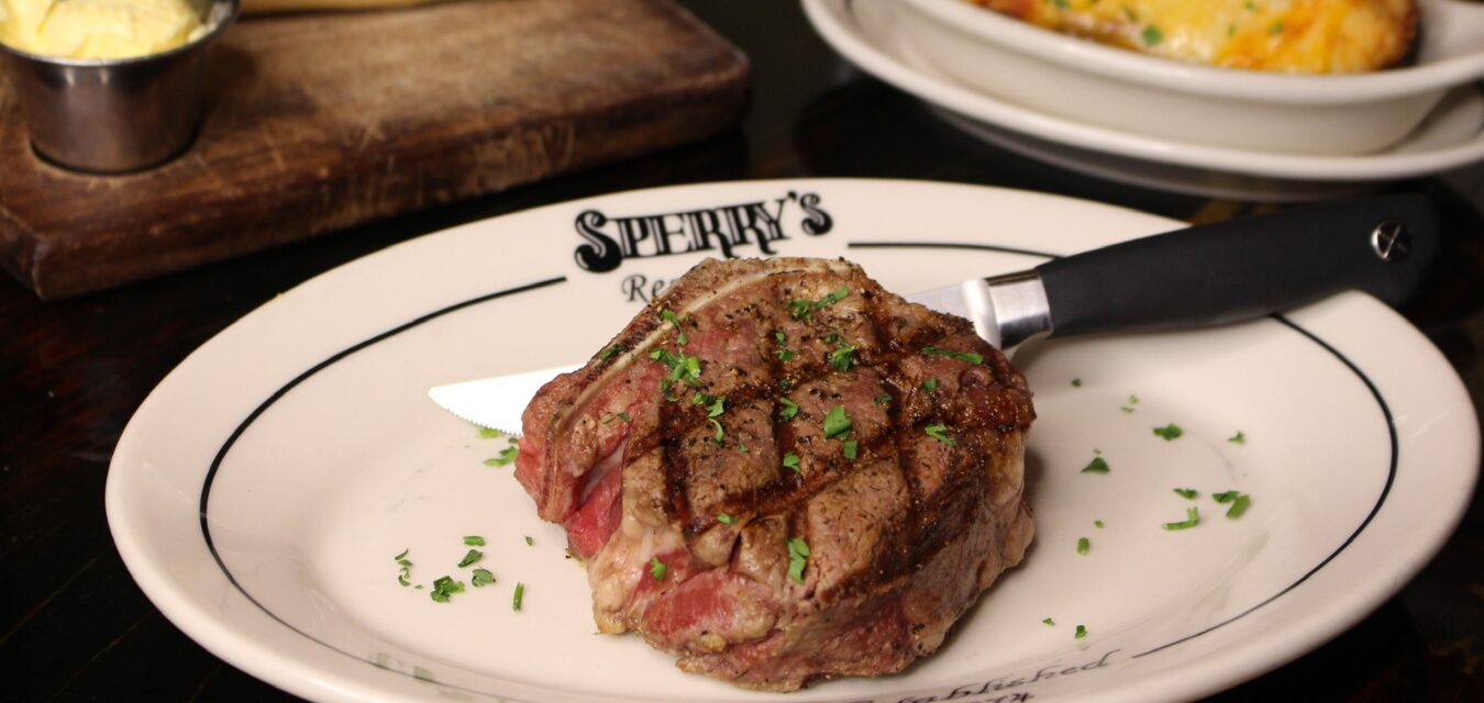 a steak on a white plate with a steak knife at Sperry's