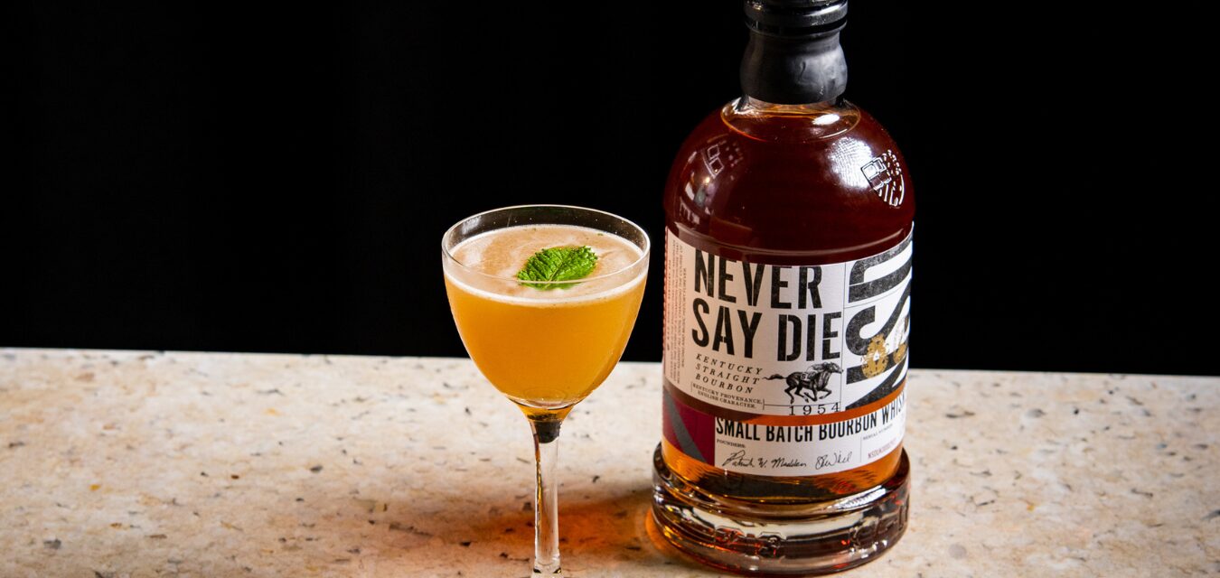 Epsom derby cocktail next to a bottle of Never Say Die Bourbon