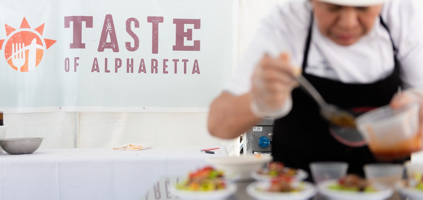 A chef puts final garnishes on dishes during Taste of Alpharetta events.
