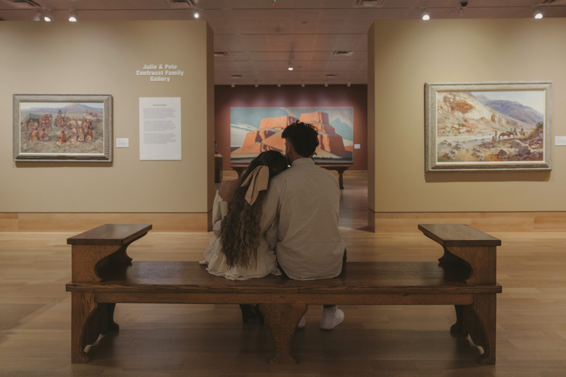A man and a women sitting on a bench admiring art together at a museum in Cartersville Georgia
