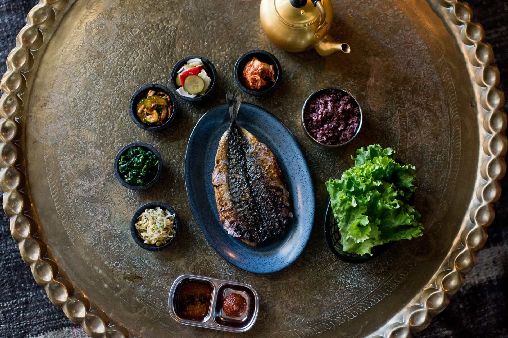 A fish dish and accompanying sides at oseyo