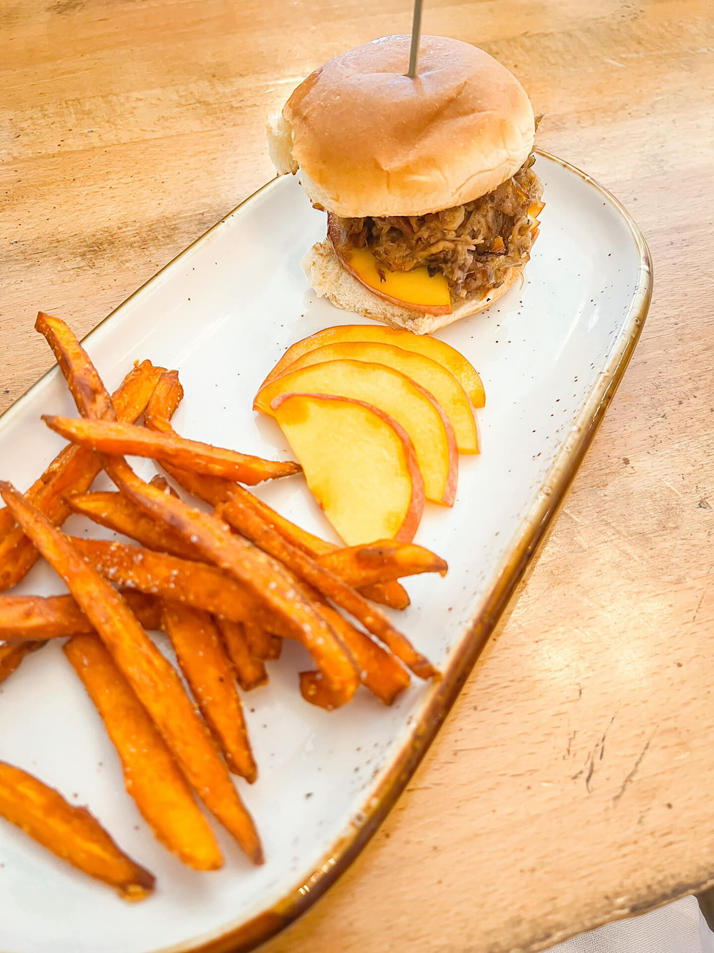 A Pinehurst Barbecue Festival pulled pork sandwich with peaches and sweet potato fries on the side. 