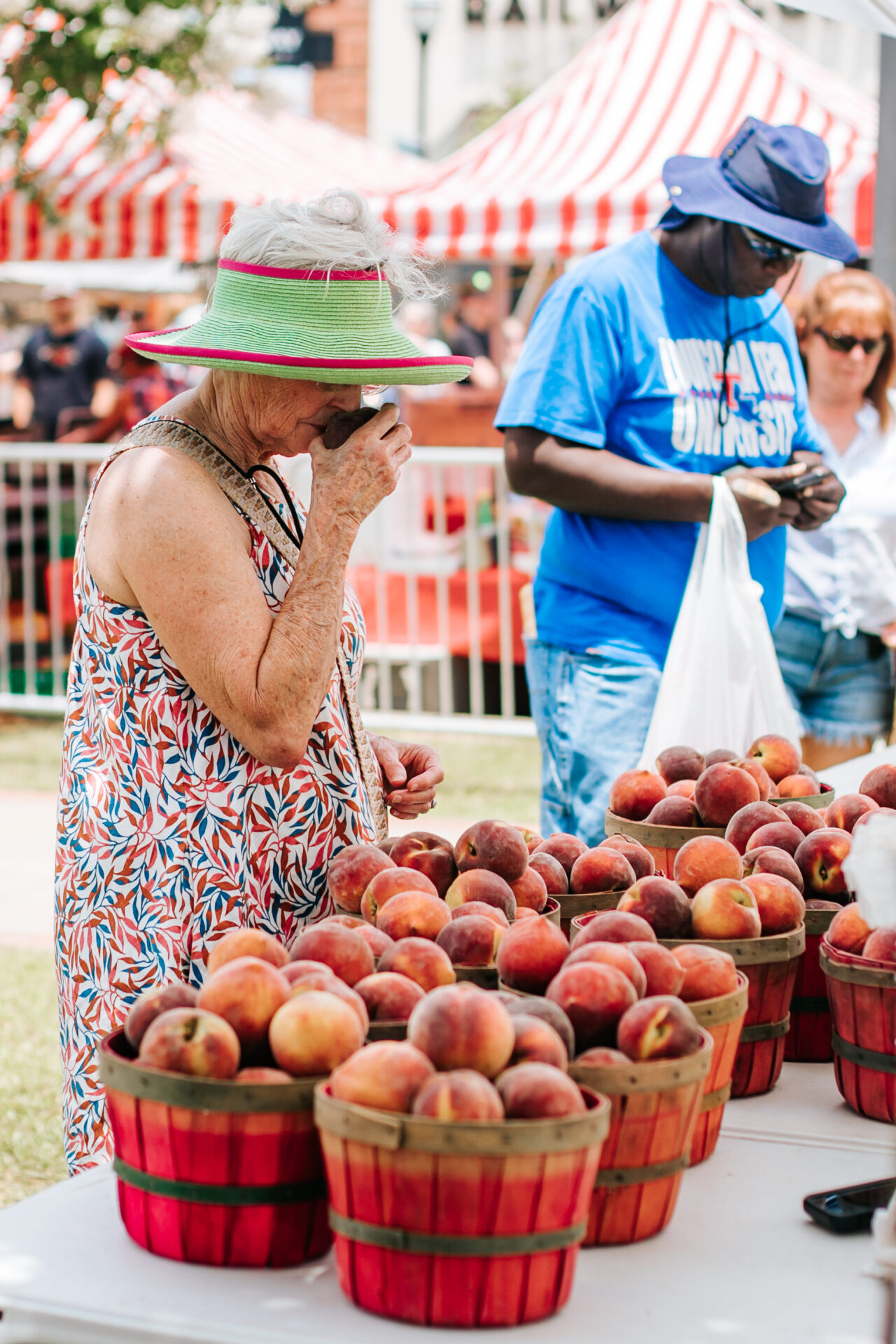 A women smelling fresh peaches at the Peach Festival in Ruston