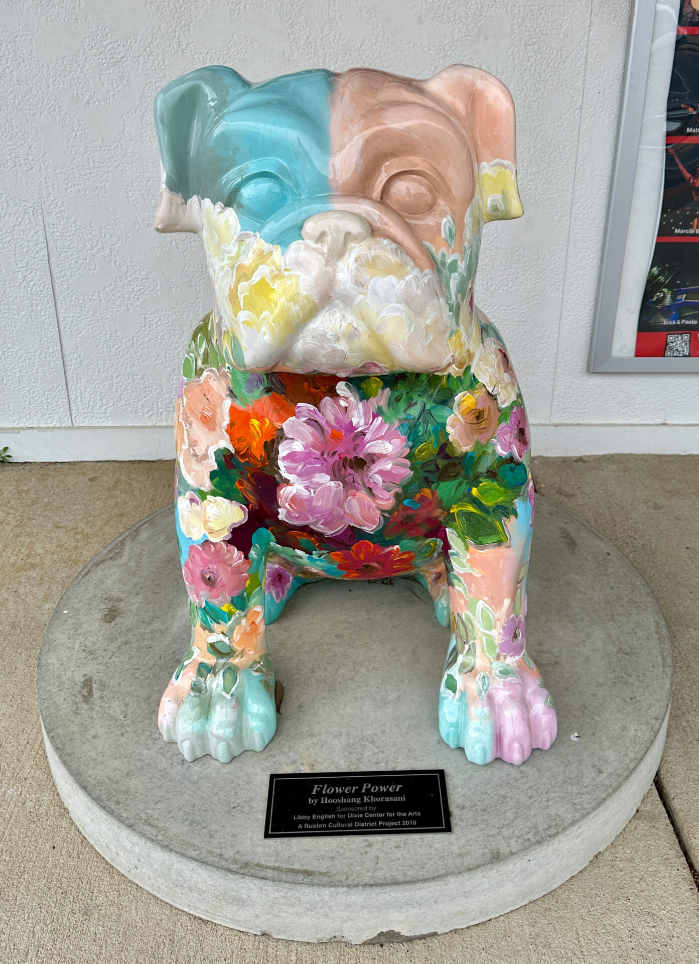 The Flower Power Bulldog in Ruston features pastel pink and blue colors on the head and a color array of hand painted flowers throughout the body.