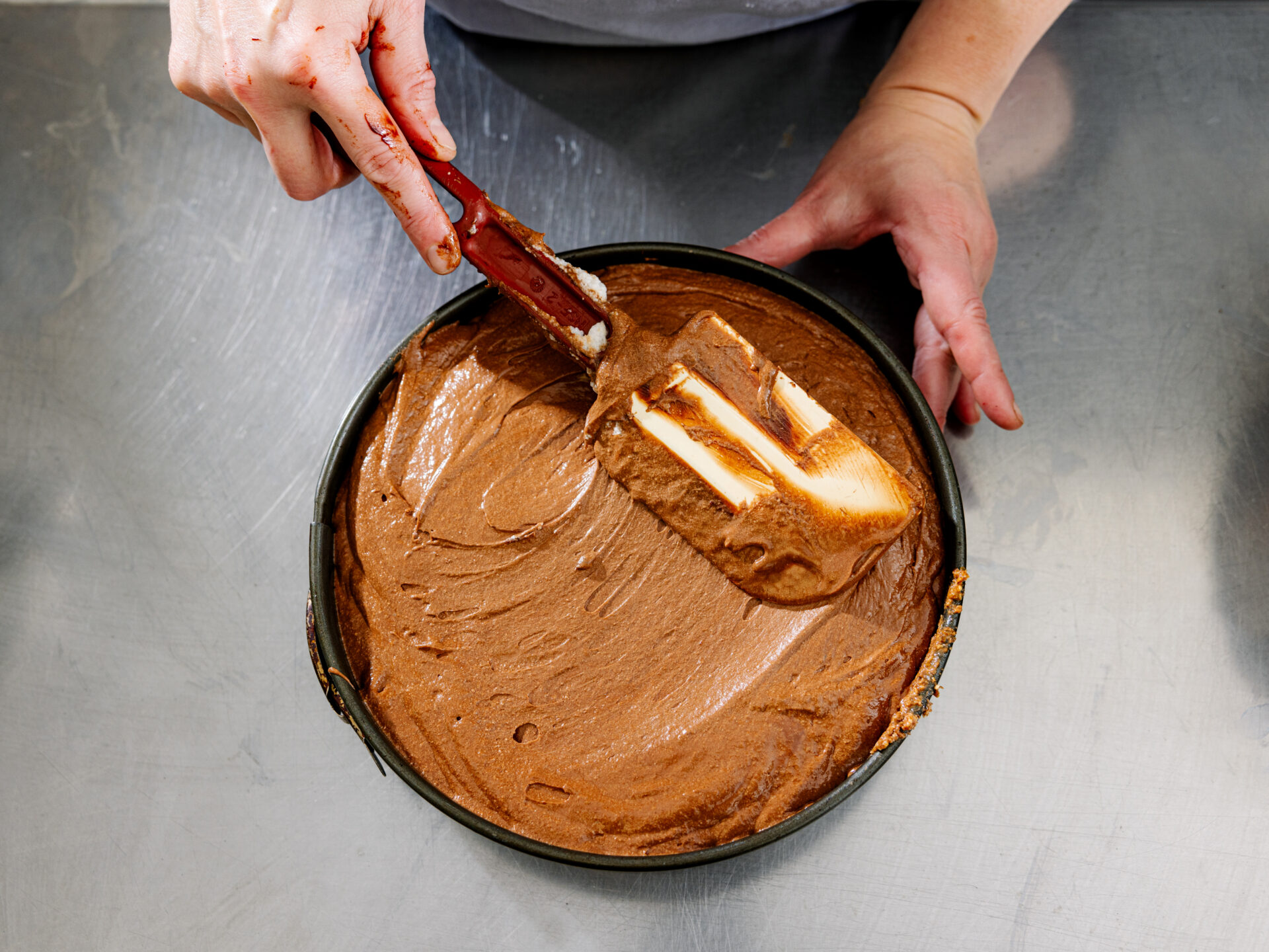 Chef spreads mousse over Chocolate Bombolo