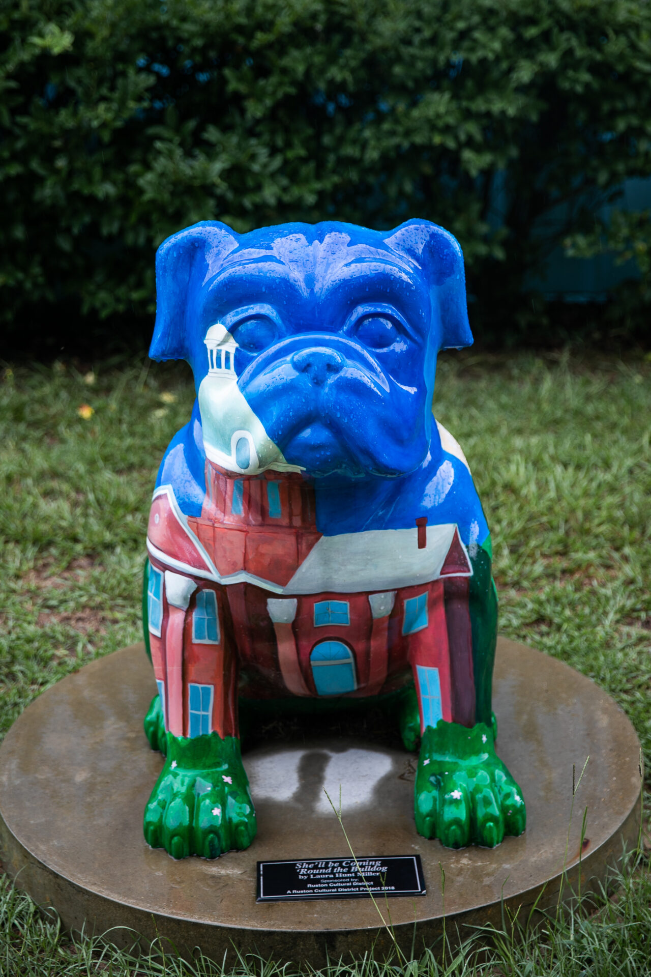 The She'll Be Comin 'Round the Bulldog sculpture in Ruston features a royal blue colored bulldog and an image of a historic building in Ruston.