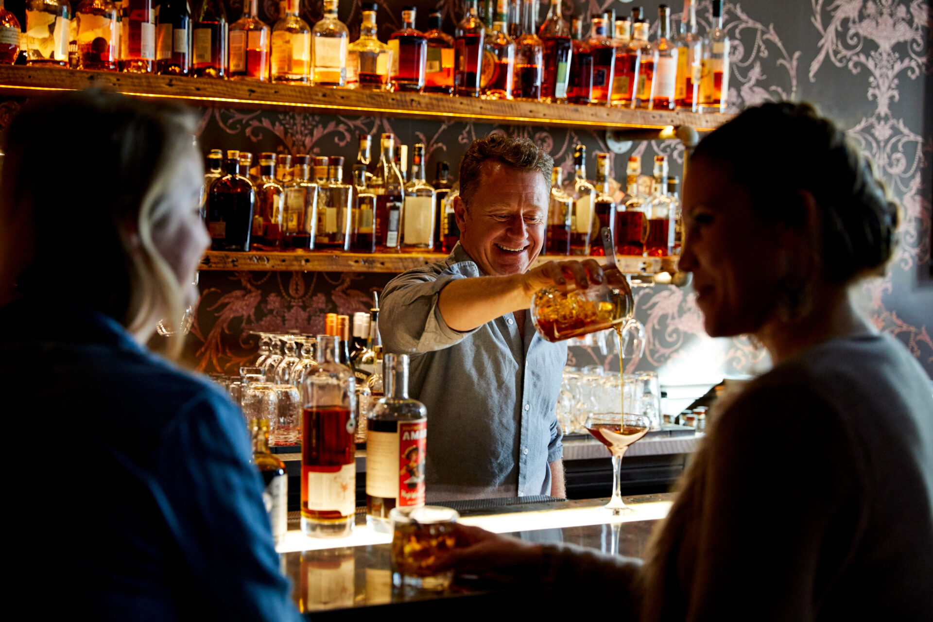 A bartender pours a drink