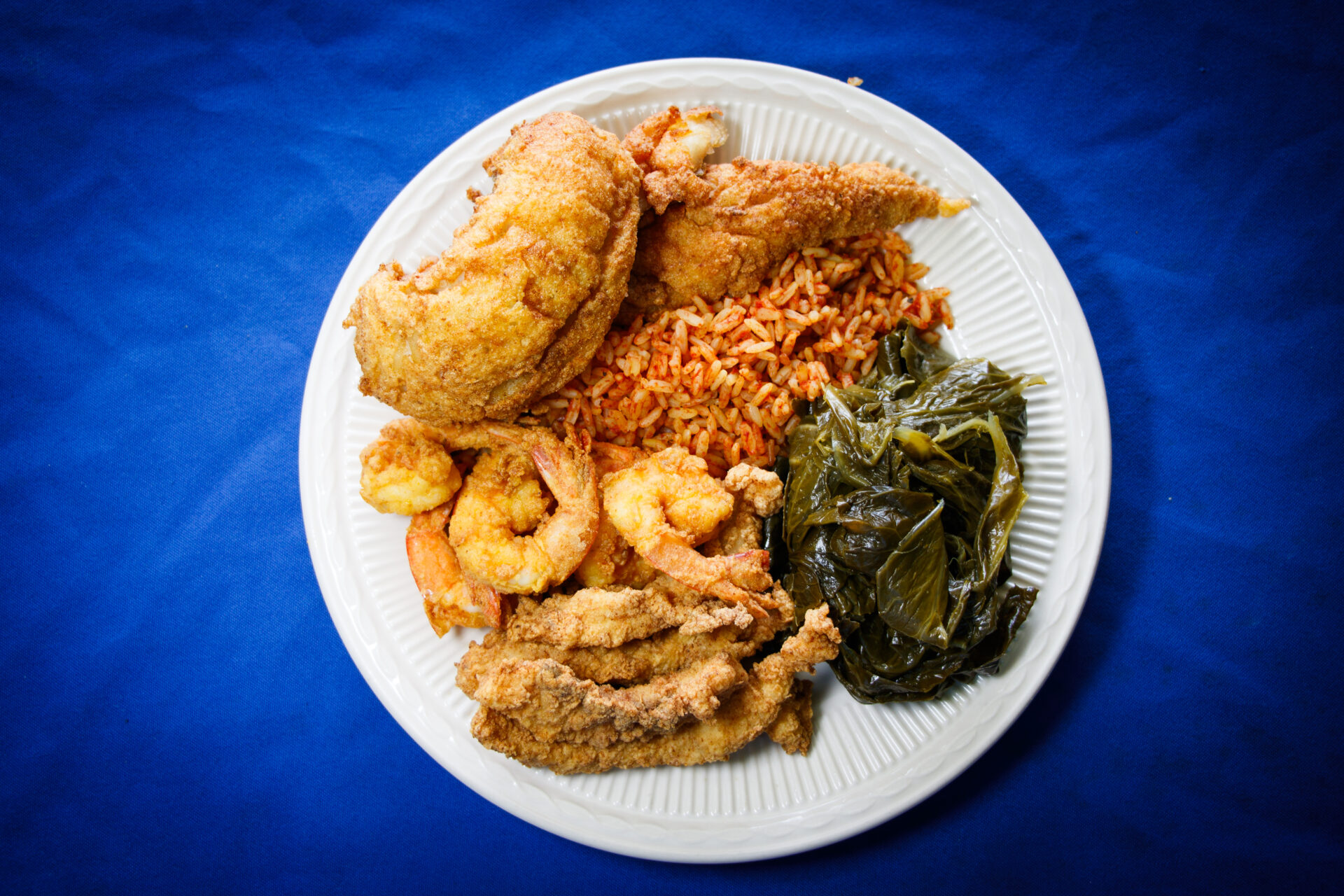 Dish with shrimp, rice, chicken, and greens from The Gullah Grub.