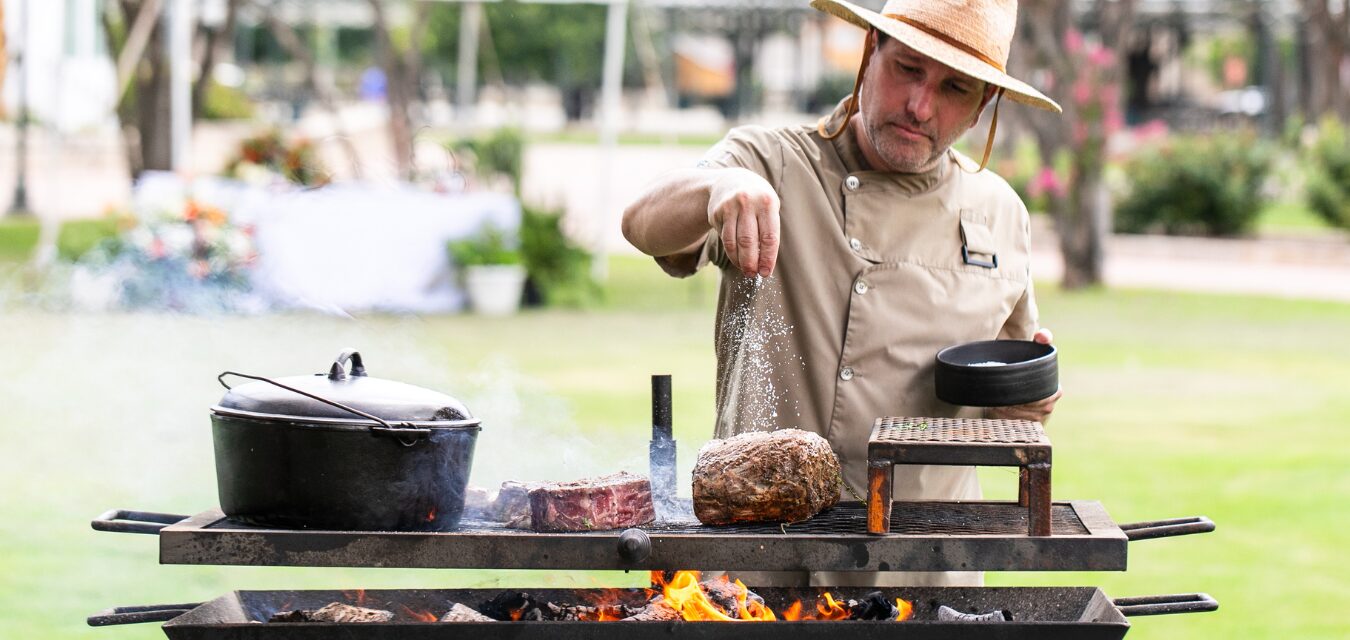 Chef grilling food over open flame at Fredericksburg Food & Wine Festival.