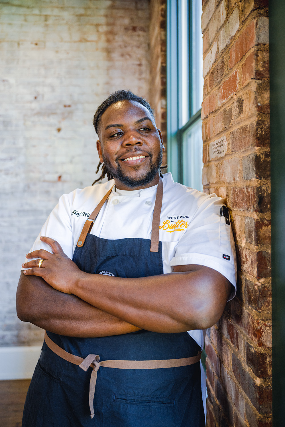 South Carolina Chef Ambassador Michael Sibert of Anonymous Burgers poses for a photo near a window. 