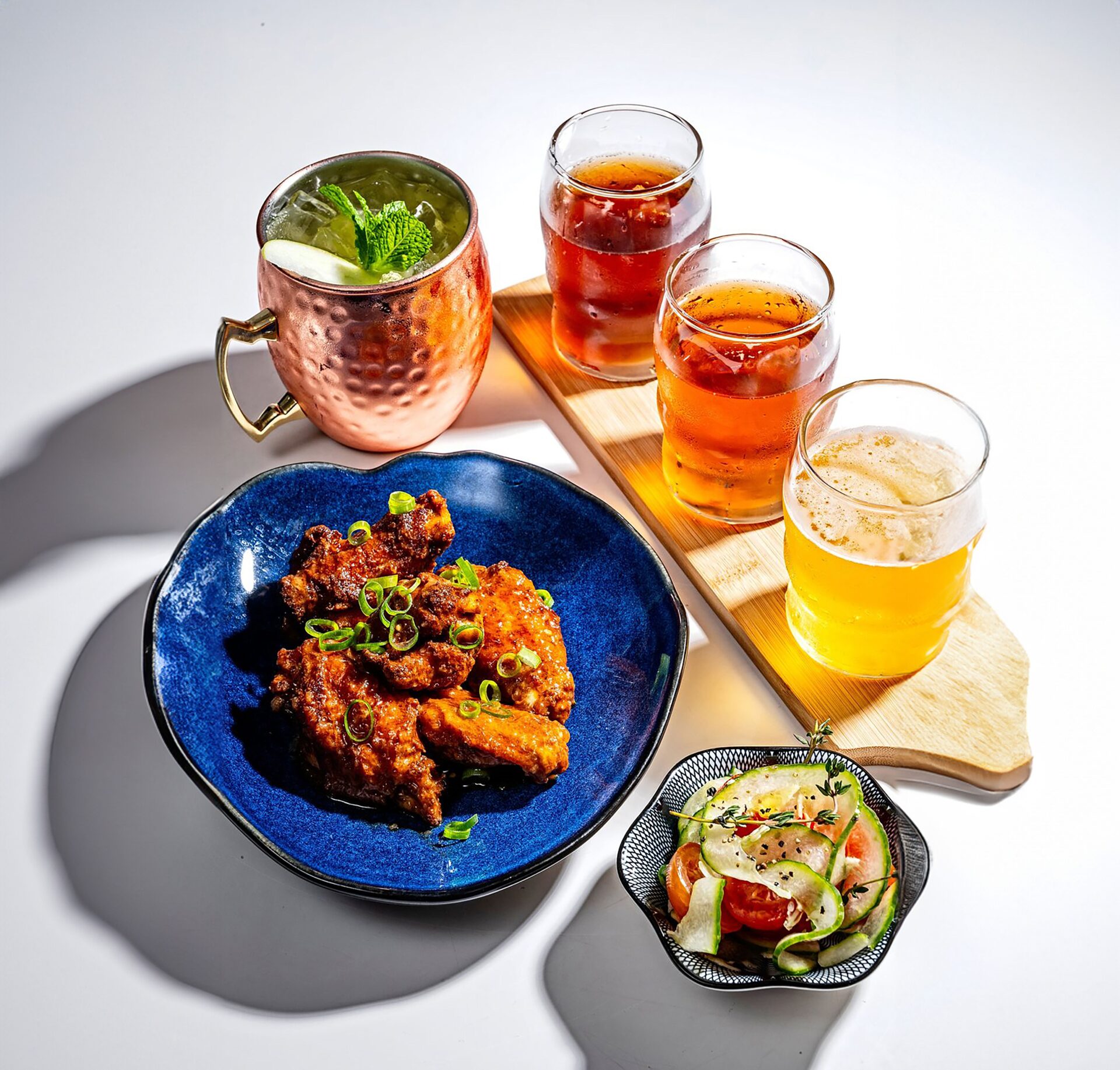 A mocktail mule, flight of non alcoholic beers, and chicken wings at a featured dry bar