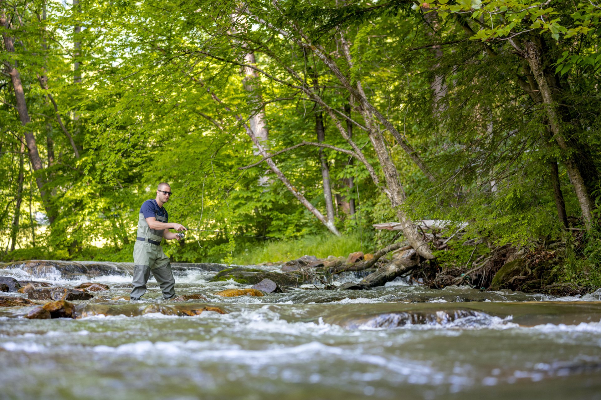 A man fishing in a river in Haywood, North Carolina.
