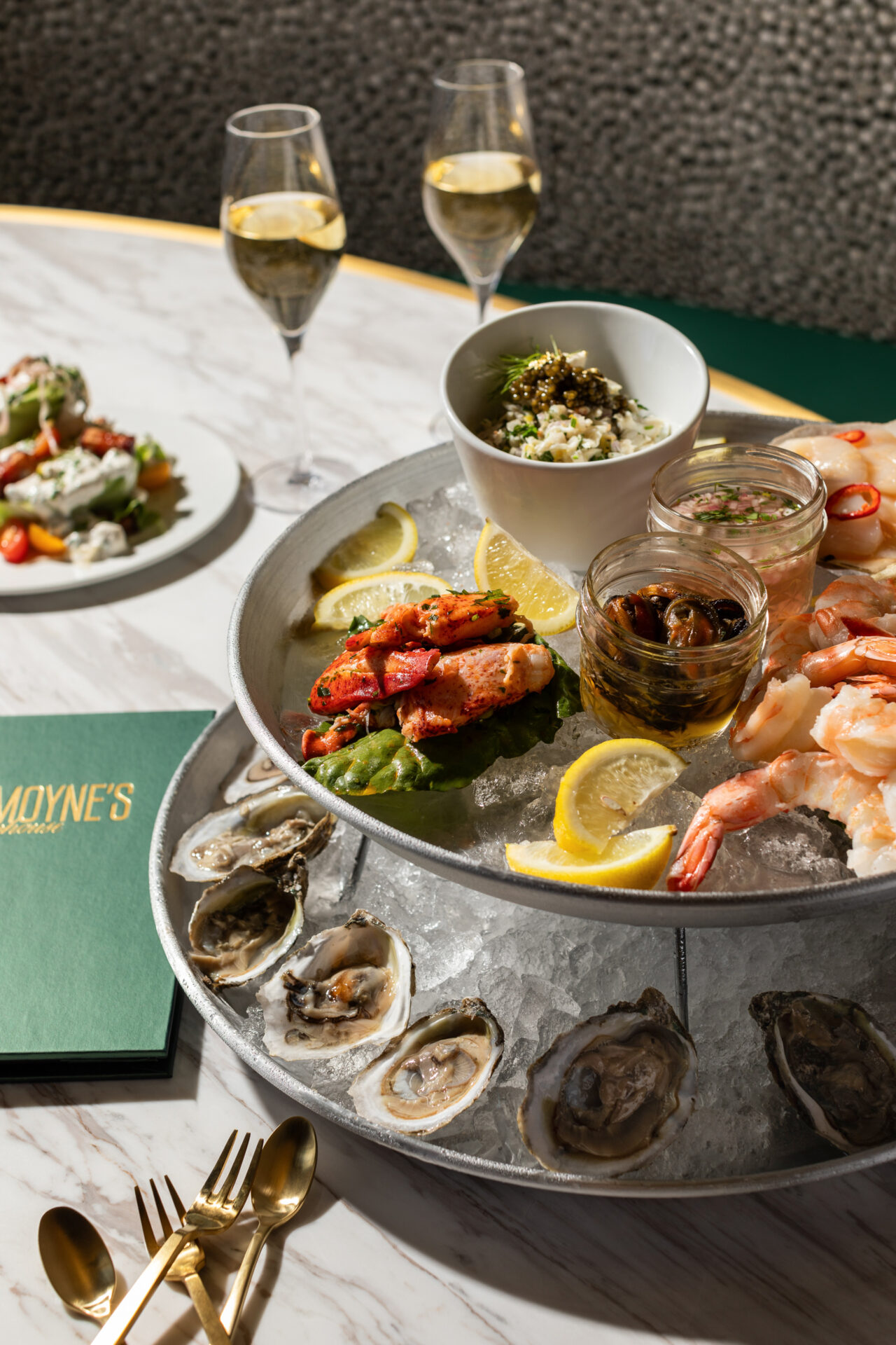 A three-tiered seafood tower with oysters, shrimp, and other seafood being served at Le Monye's Chophouse in Mobile, Alabama.