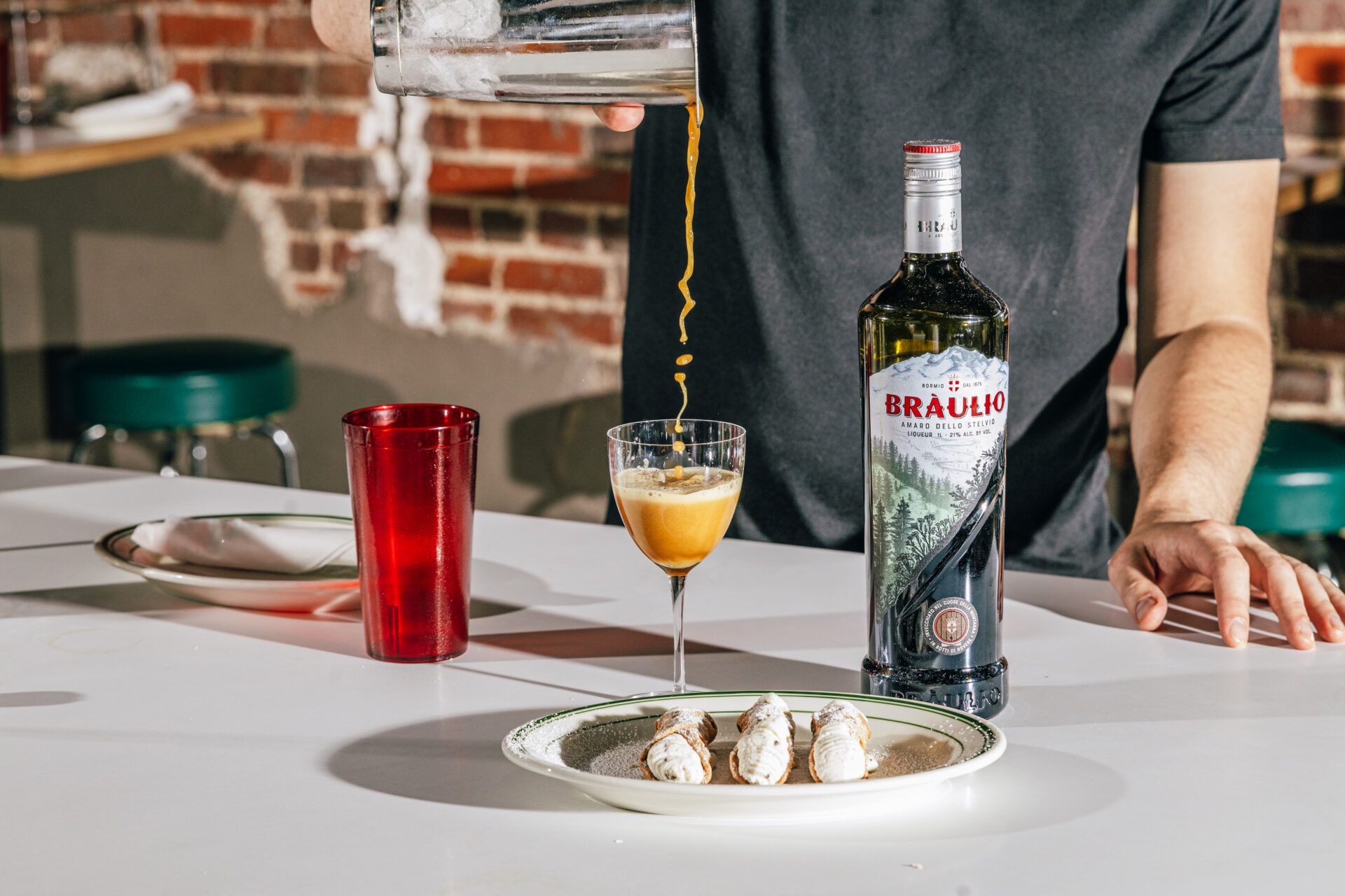 Anthony Guerra pours a braulio with cannoli