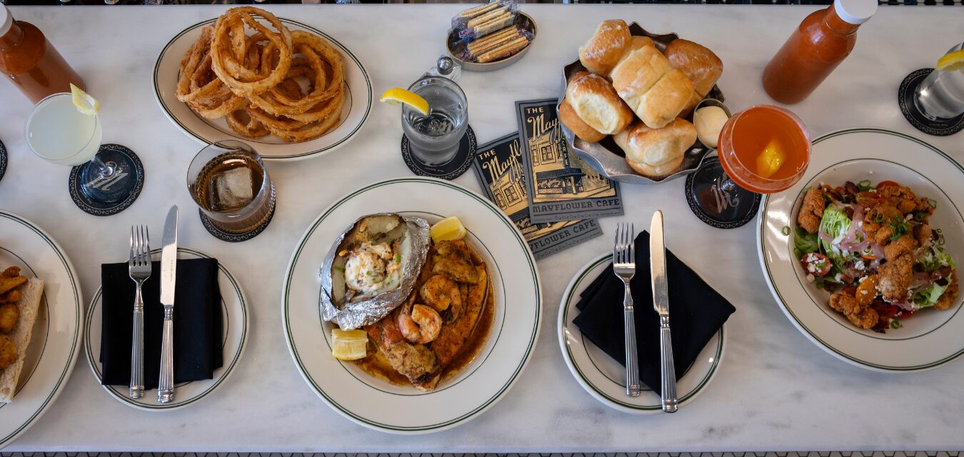A large table full of various dishes and beverages at The Mayflower in Jackson, Mississippi.