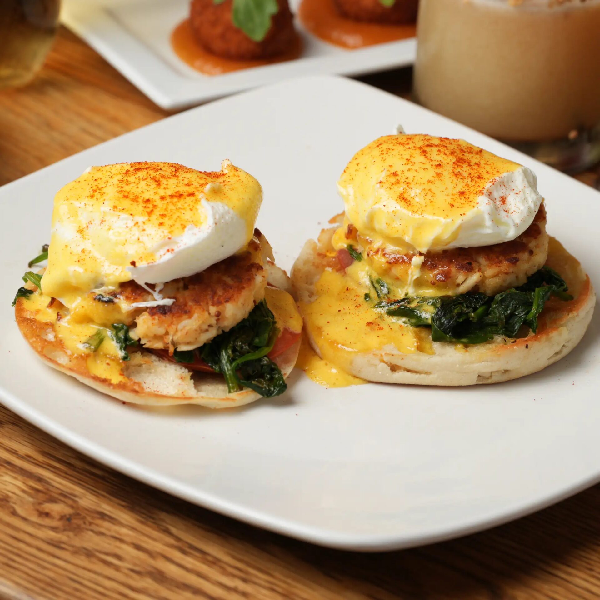 This crab cake benedict from Folk Art in Atlanta, Georgia features a toasted English muffin topped with a bed of greens, crab cake, perfectly poached egg, and hollandaise sauce.