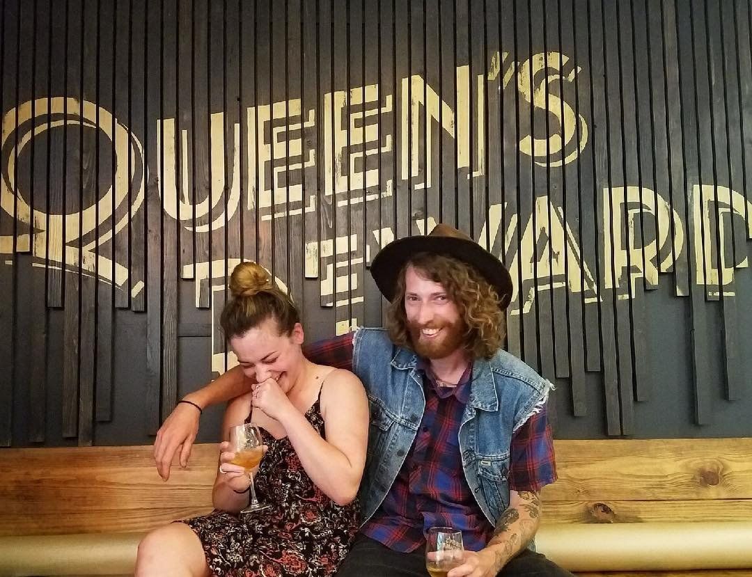 A couple laughing with drinks in their hands at Queen's Reward Meadery in Tupelo, Mississippi.
