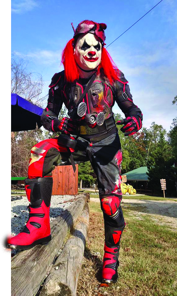 A character at Kersey Valley Spookwoods is dressed as a scary clown in bright red and black, ready to haunt guests in Randolph County, North Carolina. 