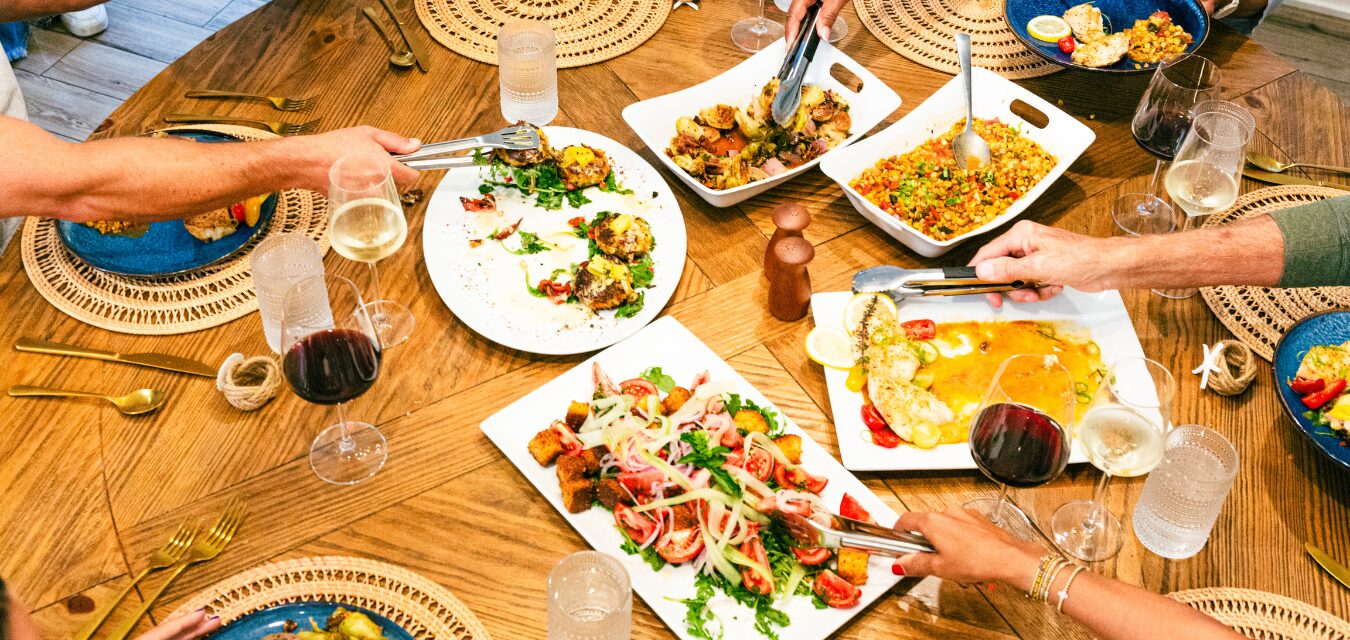 People sharing dishes across a table in South Walton